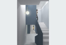Nuovo arredo d'ingresso di colore blu, che si estende lungo la parete e sul corrimano della scala, creando un effetto di continuità e armonia.